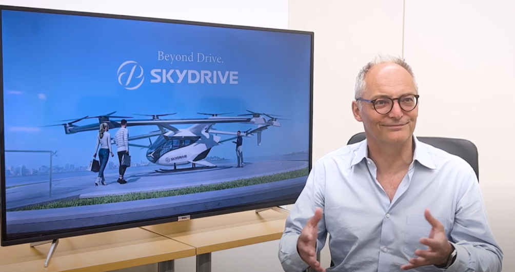 Arnaud Coville beside a display showing the SKYDRIVE aircraft