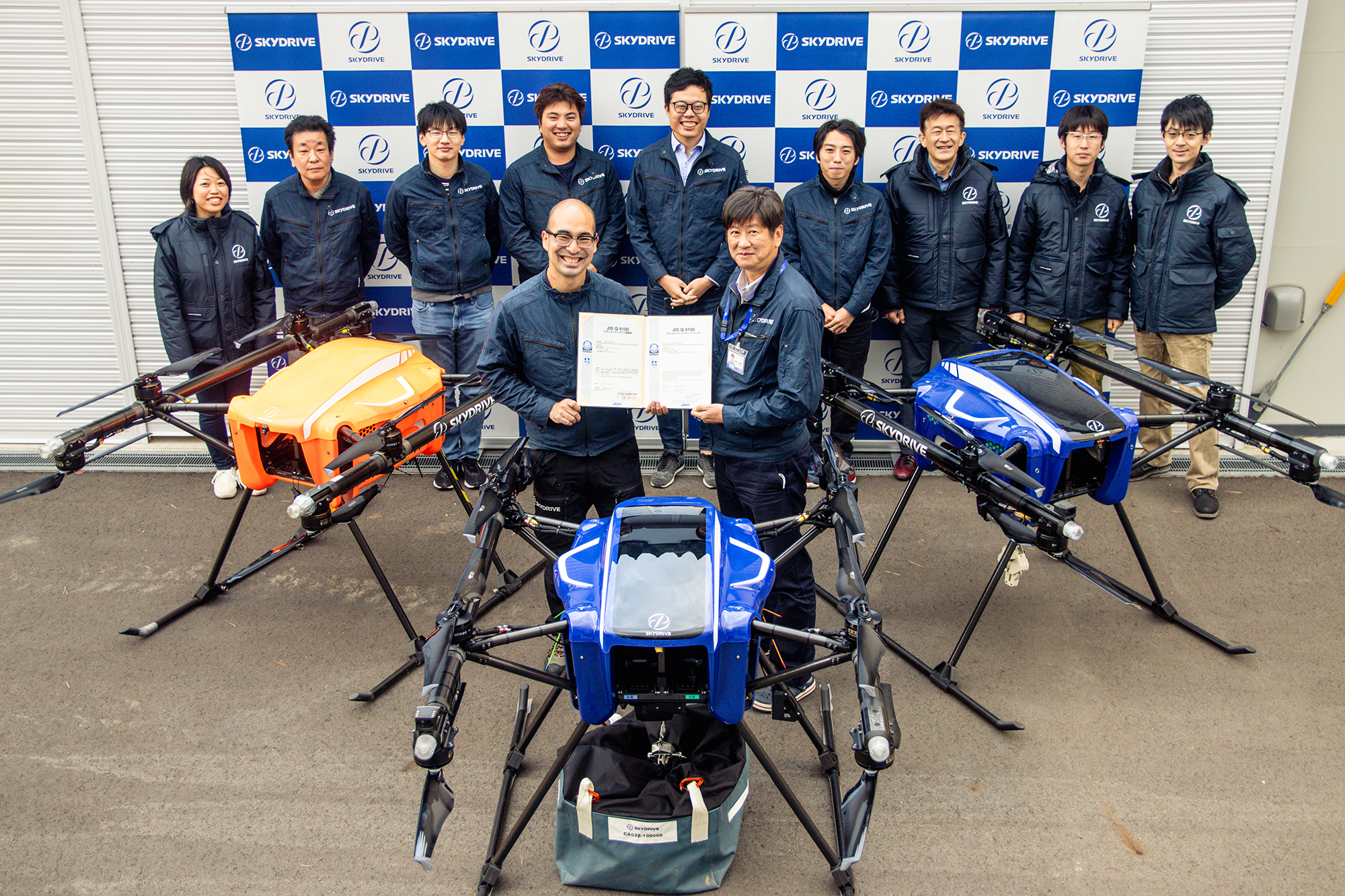 「JIS Q 9100:2016」の認定証とカーゴドローン部が開発する物流ドローン「SkyLift」